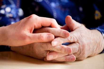 La main d'une personne âgée soutenue par la main d'une personne plus jeune